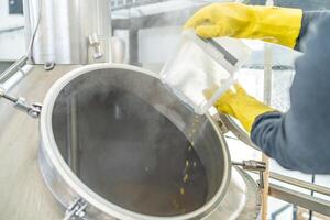 dried granulated hops in the brewery when brewing beer. added to a stainless steel tank when brewing beer photo