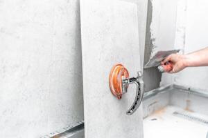 craftsman tiling the room with large format tiling photo