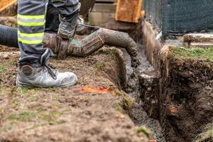 pour concrete from the mixer of the foundation of the building in the ground photo