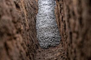 pour concrete from the mixer of the foundation of the building in the ground photo