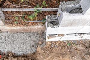 pour concrete from the mixer of the foundation of the building in the ground photo