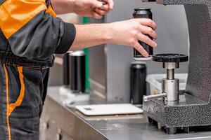 closed with the lid of beverage cans in an automatic capping machine in a brewery photo