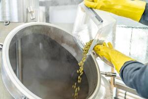 dried granulated hops in the brewery when brewing beer. added to a stainless steel tank when brewing beer photo