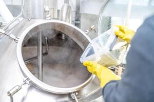 dried granulated hops in the brewery when brewing beer. added to a stainless steel tank when brewing beer photo