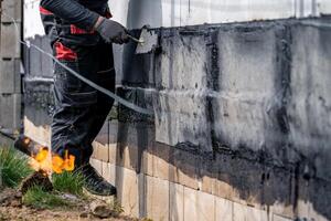 waterproofing of the wall with a covered asphalt belt during the construction of the house photo