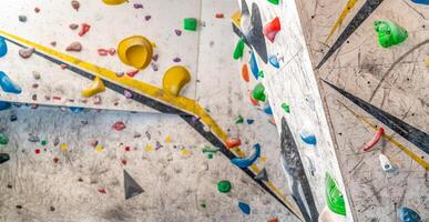 artificial climbing wall with colorful holds photo