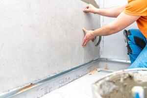 installation of large format tiles on the wall by a craftsman photo