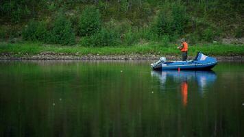 A fisherman floats on an inflatable boat on a lake and fishes video