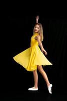 portrait of a teenage ballerina in a suit on a black background photo