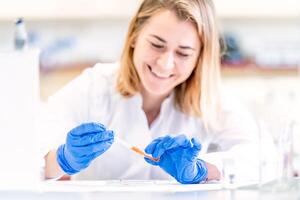 young female scientist with a smile on her face is testing a new invention in a research laboratory photo