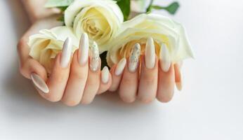 Female Hands on a white background with beautiful pearl manicure and white roses photo
