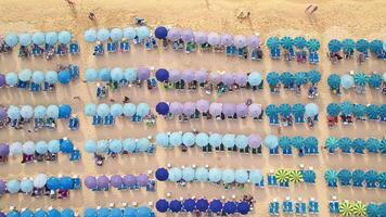 Top view of the beach with blue umbrellas and people having a rest on a sunny summer day. Azure Sea of a popular resort video