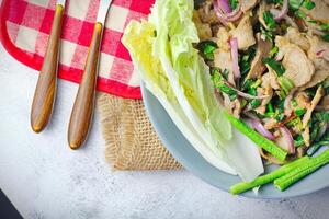 Sliced grilled beef salad, Isaan food in Thailand, local food in Thailand. Served with long beans and lettuce On a gray plate served in a Thai restaurant. photo