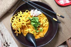 Aromatic Khao Soi with egg noodles in a rich coconut curry broth. photo