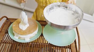 Woman Puts and Spreads Whipped Cream with Spoon on Top of Cake Layer. High Angle Shot. Slow Motion video