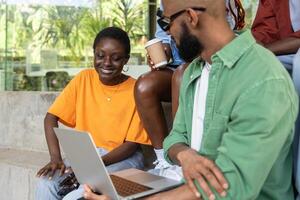 empresa de satisfecho contento africano americano estudiantes estudiando fuera de utilizando ordenador portátil computadora. foto