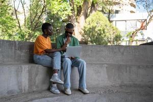 Thoughtful boyfriend, girlfriend classmates using computer to study sitting on campus stairs outside photo