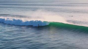 Drone view with surfing on ideal swell wave. Perfect waves with surfers in ocean at Bali video