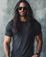 A handsome model with long hair poses in a minimalist environment while wearing a t-shirt photo