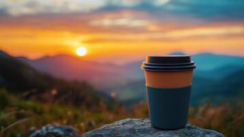 A coffee cup sits on a rock overlooking a mountain range photo