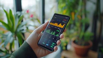 A close-up of hands holding a smartphone with a stock trading app photo