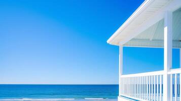 A tranquil beachfront house basking under a bright blue sky and ocean photo