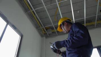 An electrician in uniform is inspecting the electrical system in a house. video