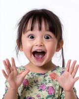 A young girl beams with joy, hands raised in delight and surprise photo