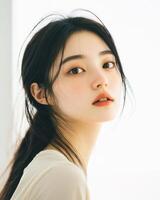 A young woman gazes thoughtfully while illuminated by gentle light photo