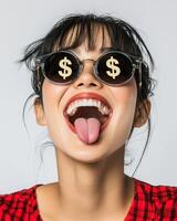 A playful woman expresses happiness with sunglasses and a cheeky grin photo