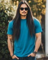 A handsome model showcases a blank blue t-shirt in a sunlit garden photo