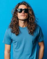 A handsome model with long hair poses confidently in a blank t-shirt photo