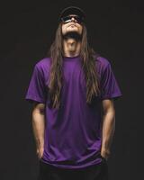 Model displays a blank t-shirt with confidence in a moody setting photo