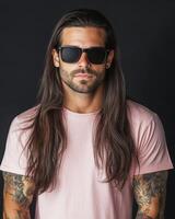 A handsome model poses confidently in a blank t-shirt against a dark backdrop photo