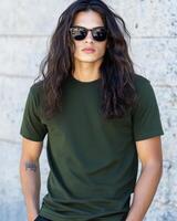 Model with long hair flaunts a blank t-shirt against a textured wall backdrop photo