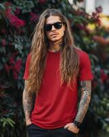Model poses confidently in a red t-shirt among colorful foliage photo