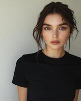 A confident woman models a blank black t-shirt against a simple backdrop photo