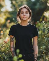 Woman stands proudly wearing a blank black t-shirt in a vibrant garden photo