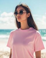 Young woman models a pink t-shirt while basking in sunny beach weather photo
