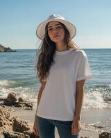 Model stands on the beach wearing a blank white t-shirt against a serene ocean backdrop photo