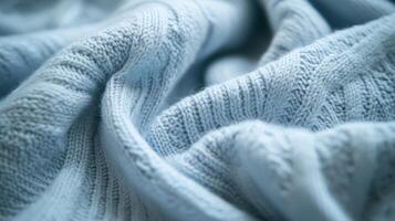 Delicate textures of a cozy blue knit fabric cascade softly in warm sunlight photo