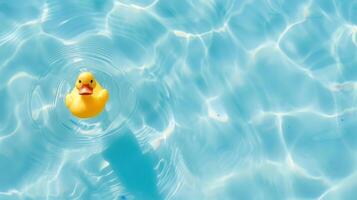 A yellow rubber duck is floating in a pool of water photo