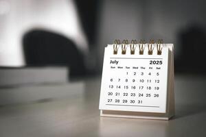 Calendar page July of the year 2025 white color in meeting room in office. with copy space and business design. concept of planning and setting new strategic goals. photo