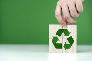 mano lugares de madera bloques con verde reciclaje iconos conceptos de ambiental , ecología, rsc, cero desperdiciar, red cero, y mundo ambiente día. con Copiar espacio foto