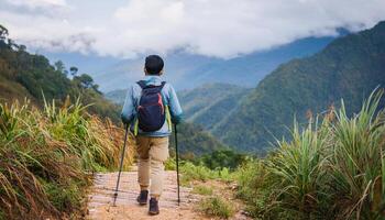 An alone asian man view from behind walking on the path for mountain trekking with beautiful mountain view photo