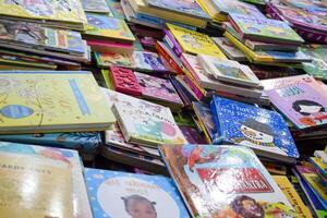New Delhi, India, July 17 2024 - Variety of Books on shelf inside a book-stall at Delhi International Book Fair, Selection of books on display in Annual Book Fair at Bharat Mandapam complex photo