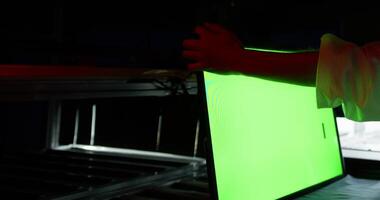 An operator on the conveyor checks the operability of the TV monitor video