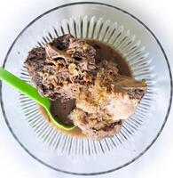 Konro soup is a typical Bugis-Makassar food made from beef ribs or bones wrapped in beef cooked with spices, and served warm, a bowl of kondro soup isolated on a wooden press and white BG photo