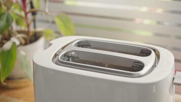 Close up of sliced bread popping out of electric toaster on wooden desk video