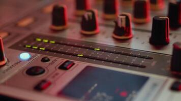 Close-up view of mixing console with moving volume indicator. Sound level signal changes vertical lights on a DJ mixer during a party with color illumination video